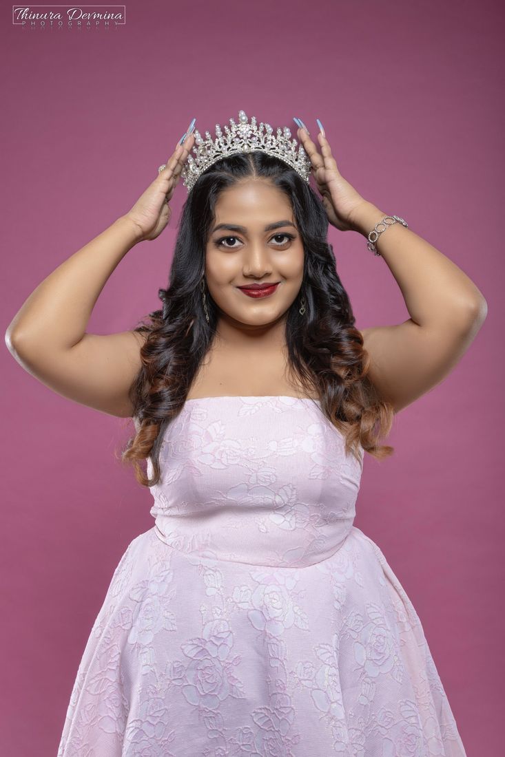 Birthday portrait of a woman placing a pearl crown on her head